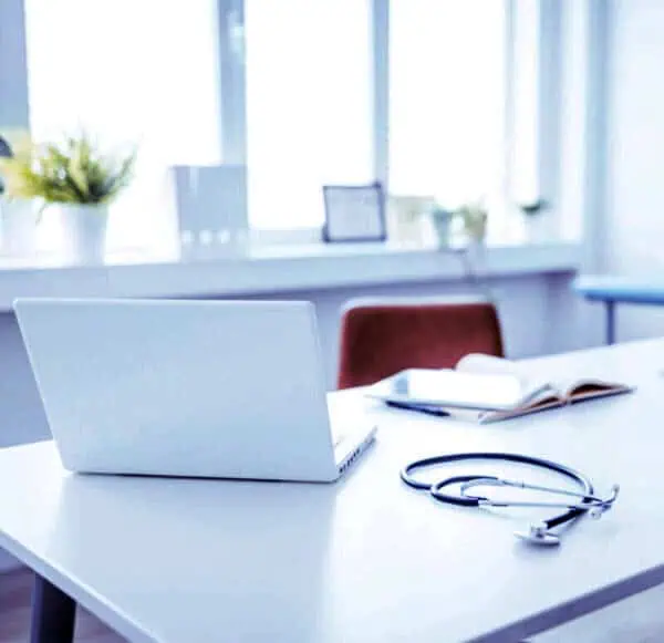 Studio professionale luminoso con scrivania, computer e stetoscopio, a rappresentare uno spazio accogliente e riservato per il primo contatto con la psicoterapeuta.